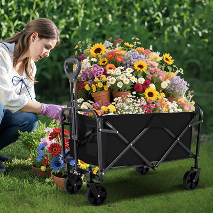 Woman arranging flowers around a black folding wagon in a garden setting
