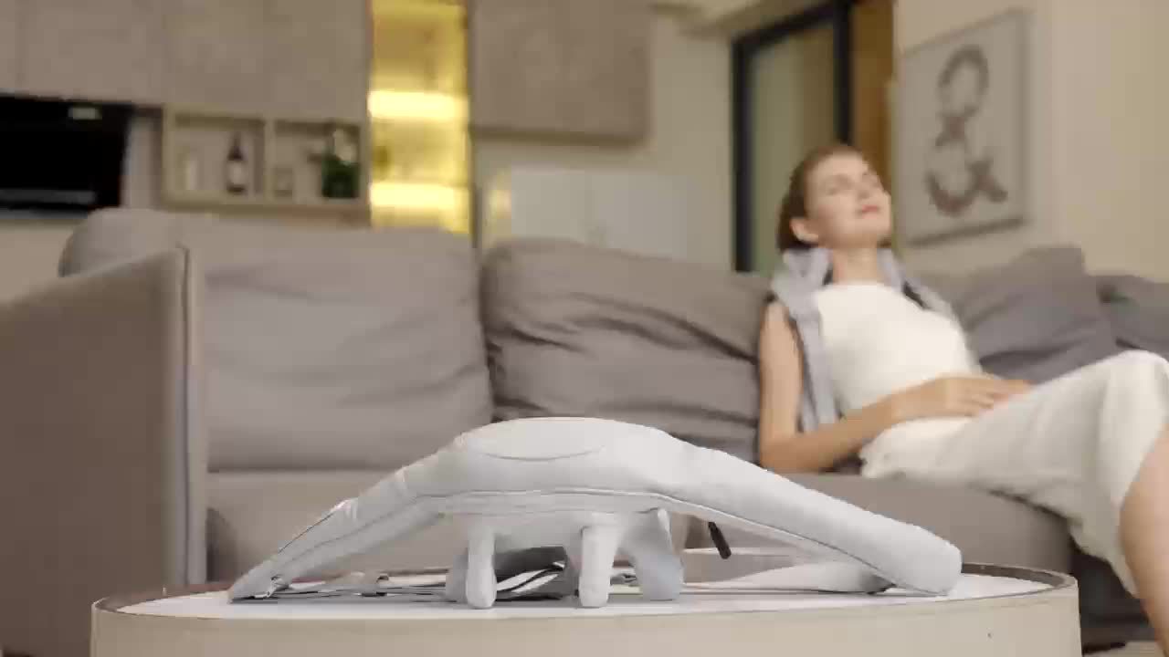 Woman sitting on a couch with a device on a table in front of her