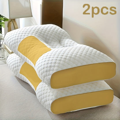 Two white and yellow pillows on a bed in a bedroom setting.